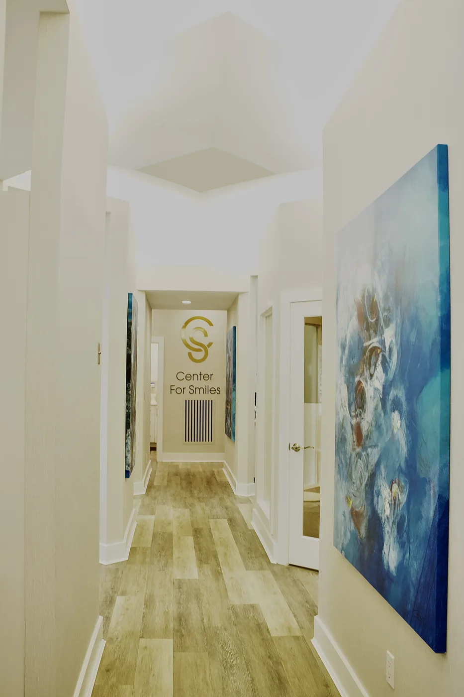 Center for Smiles Bayside office hallway with artwork and wood floors