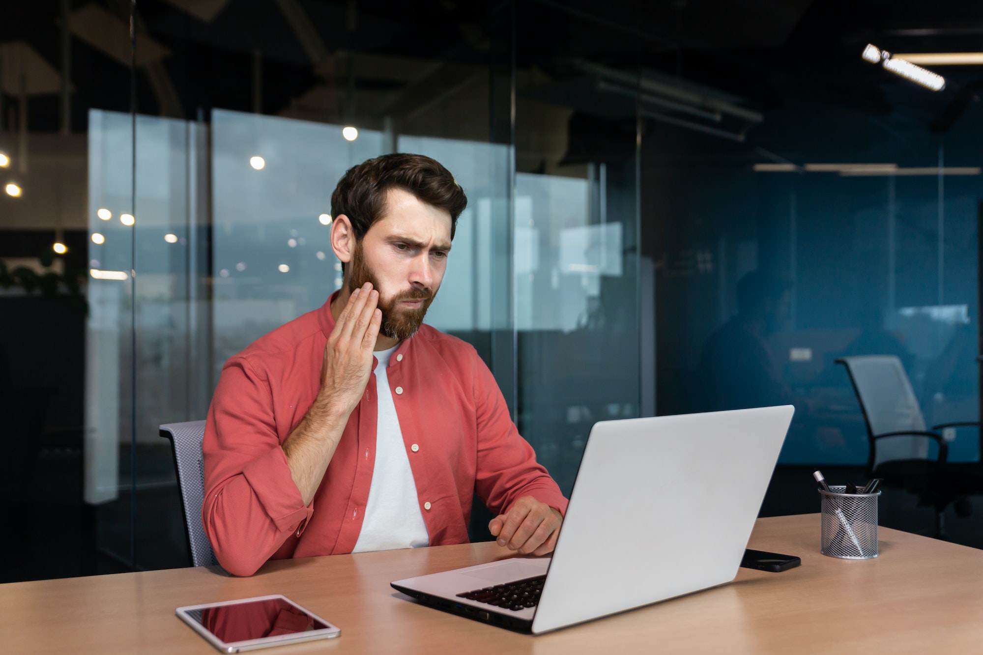 Office worker has a toothache, a sick businessman works inside the office with a laptop, a man has